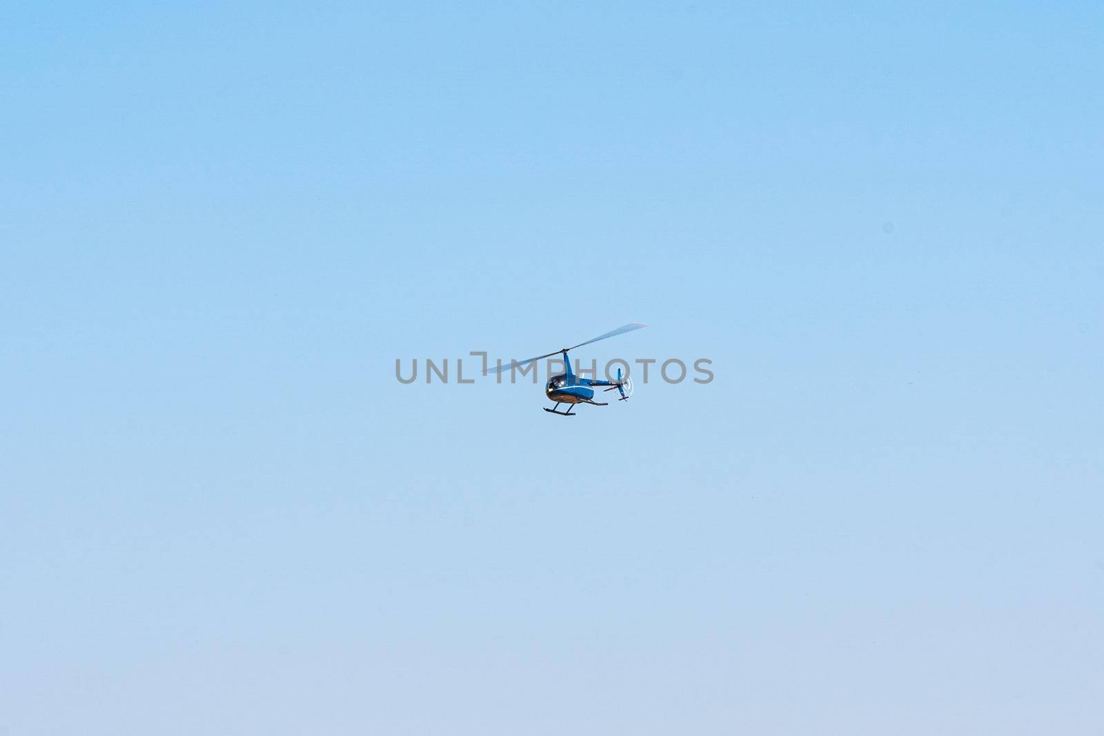 Helicopter flying in the blue sky during a sunny day