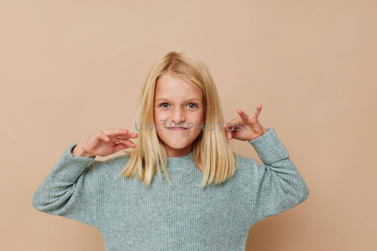 emotional girl in a sweater, grimaces kids lifestyle concept. High quality photo