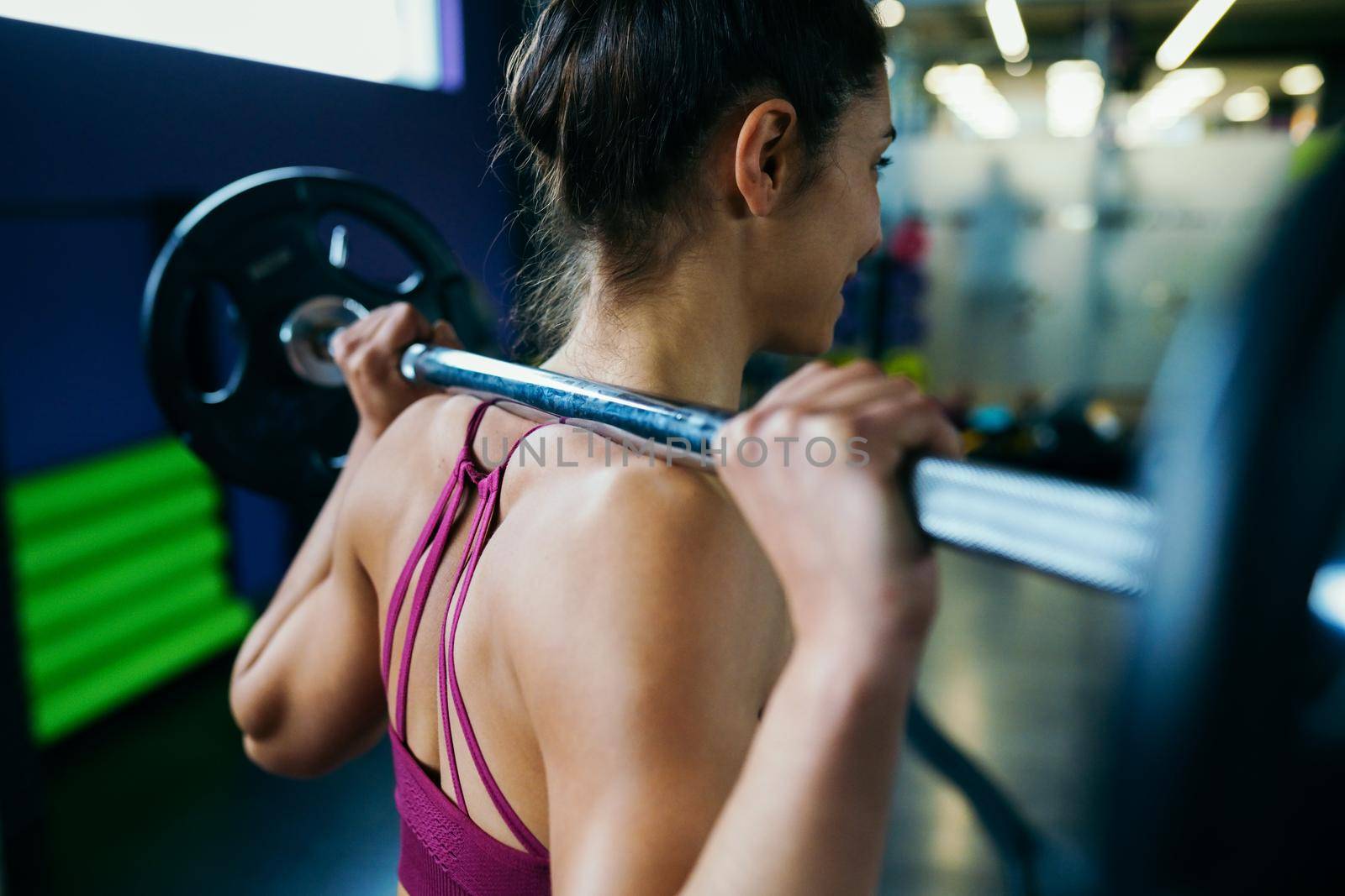 Athletic woman in gym lifting weights at the gym. Fitness concept.