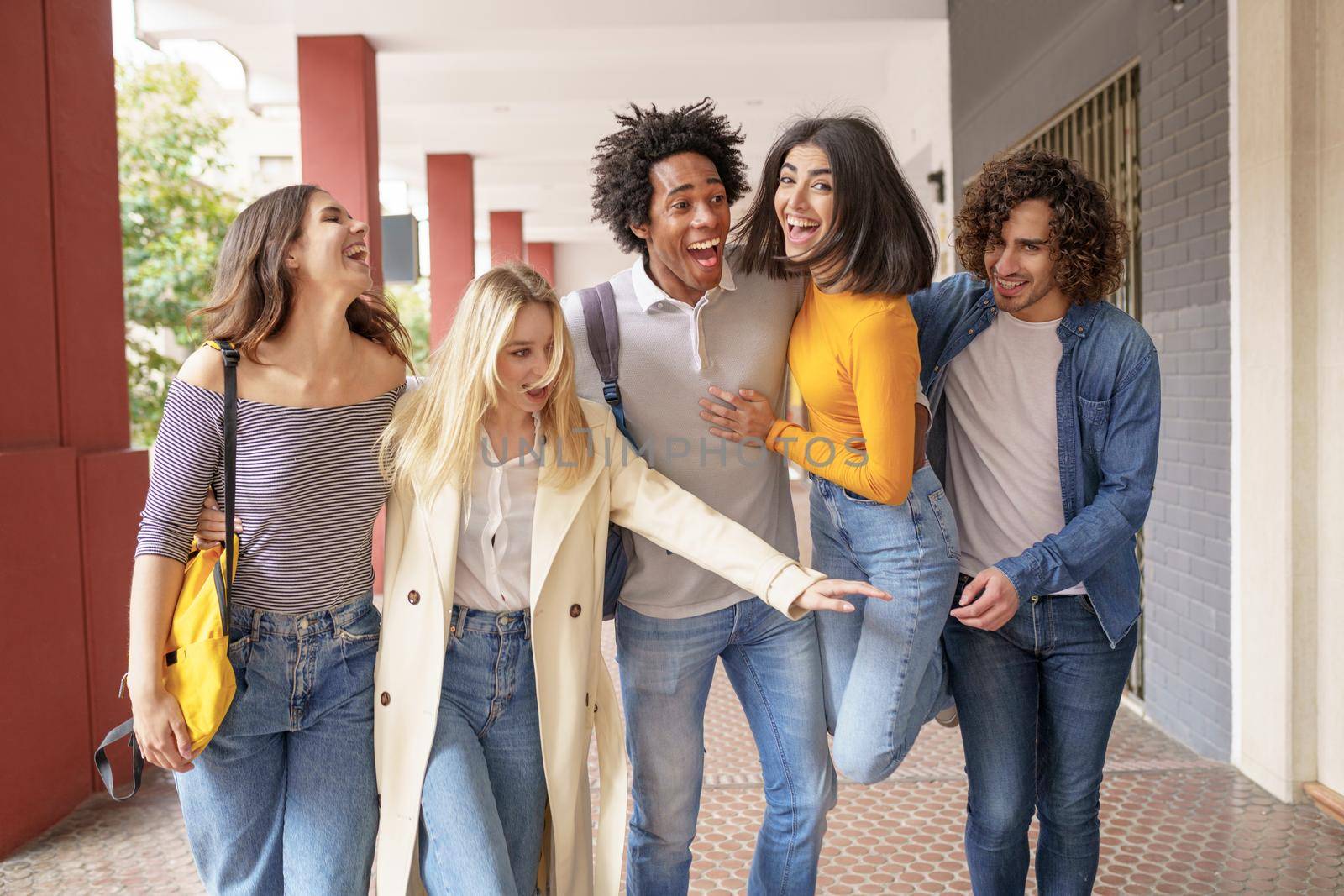 Multi-ethnic group of friends walking together on the street while chatting and having fun.