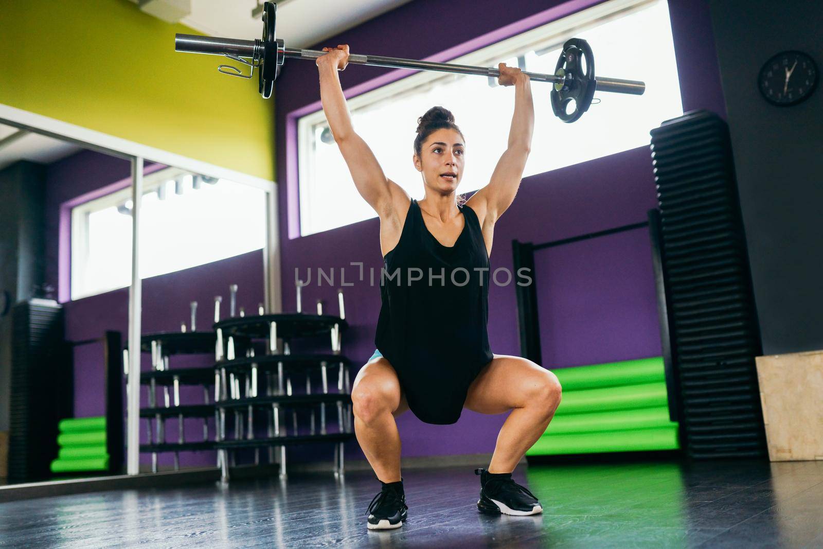 Athletic woman in gym lifting weights at the gym. Fitness concept.