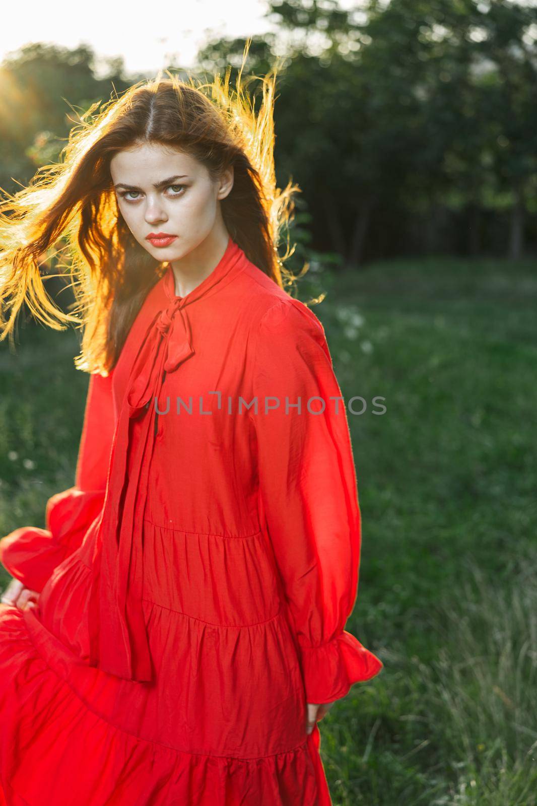 attractive woman in red dress outdoors in freedom field by Vichizh