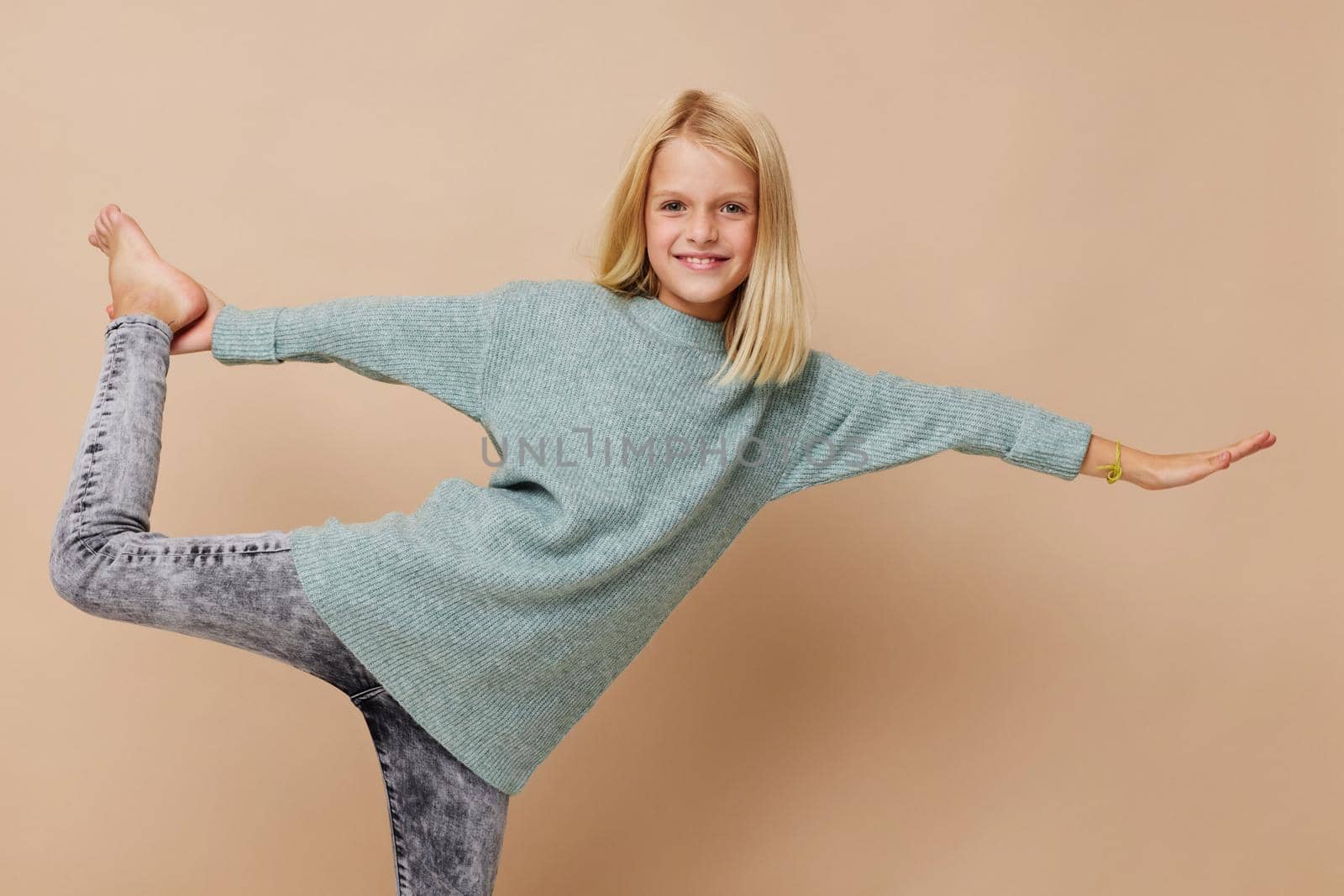 Little cute girl in a sweater, grimaces kids lifestyle concept. High quality photo