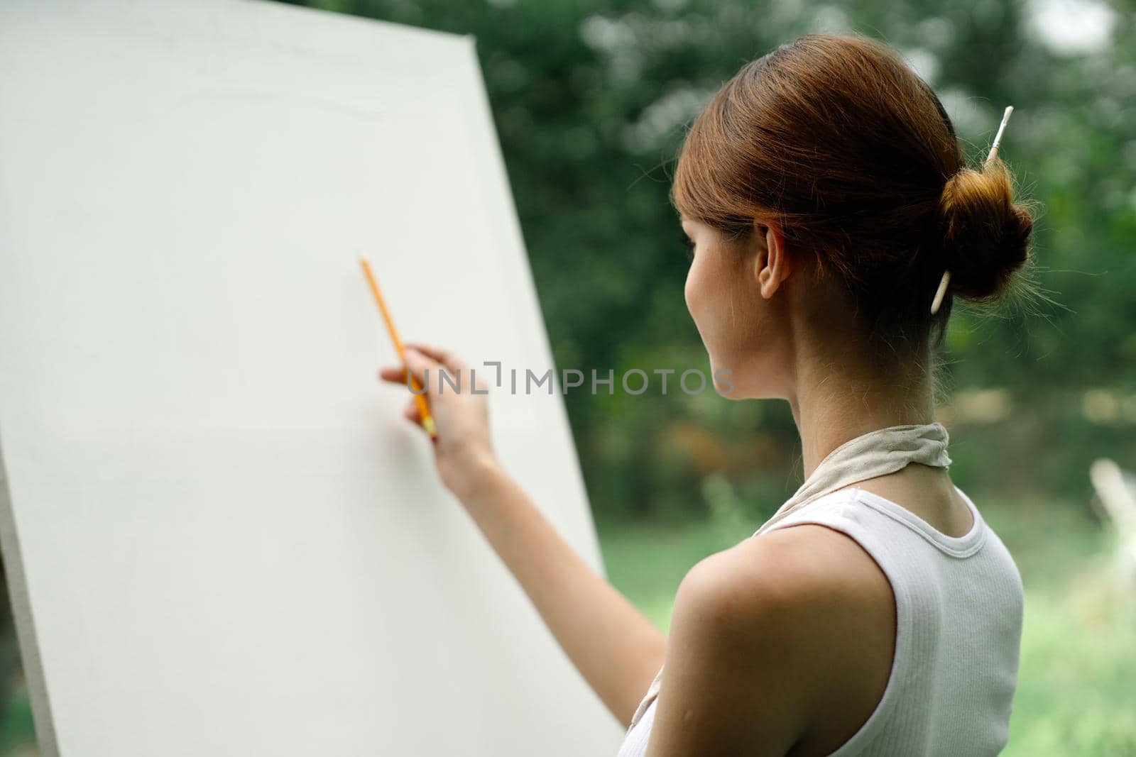 woman outdoors painting a picture creative art landscape. High quality photo