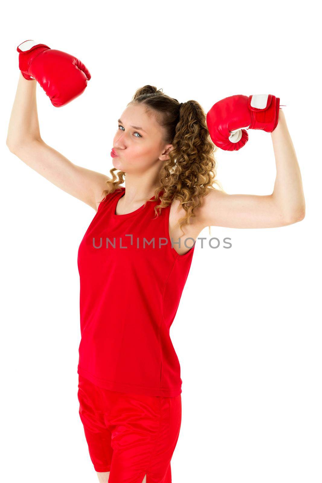 Pretty blonde teen girl boxer showing her muscles. Funny girl athlete with curly hairstyle demonstrating her power against isolated white background. Sports healthy lifestyle, girls power concept
