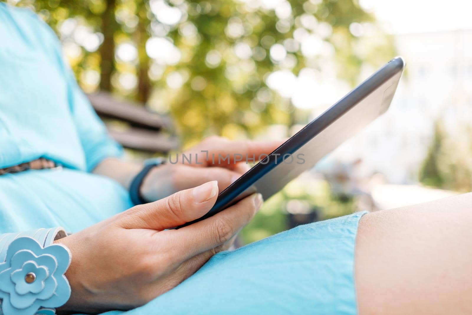 Woman using digital tablet outdoor. by alexAleksei
