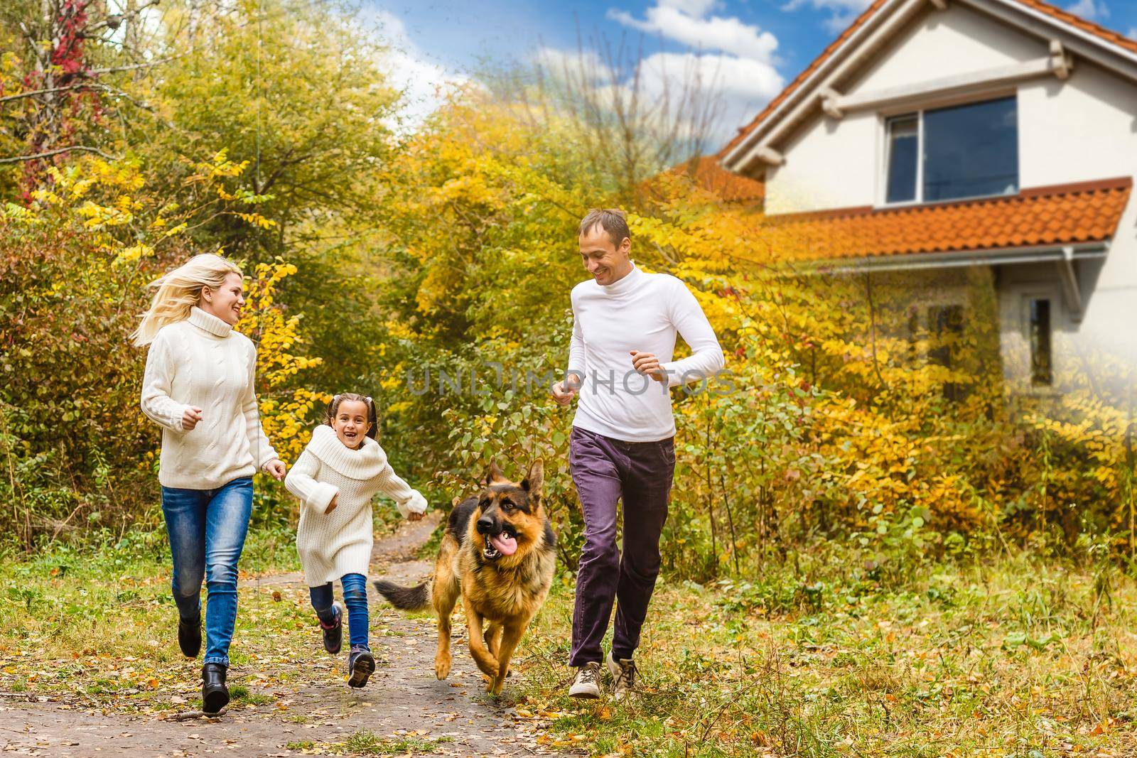 Happy family near new house. Real estate concept. by Andelov13