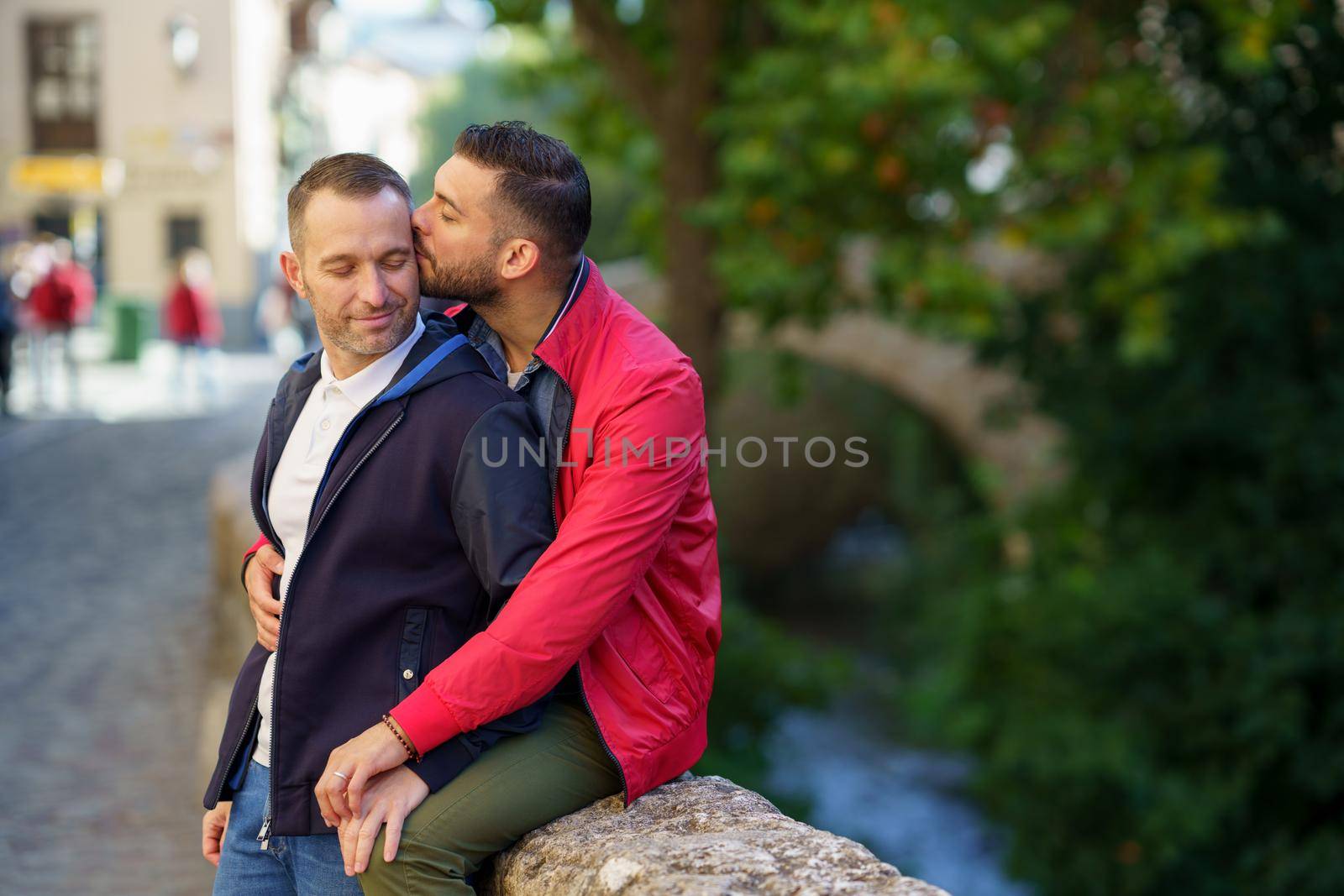 Gay couple kissing a beautiful place near the river. Homosexual relationship concept.