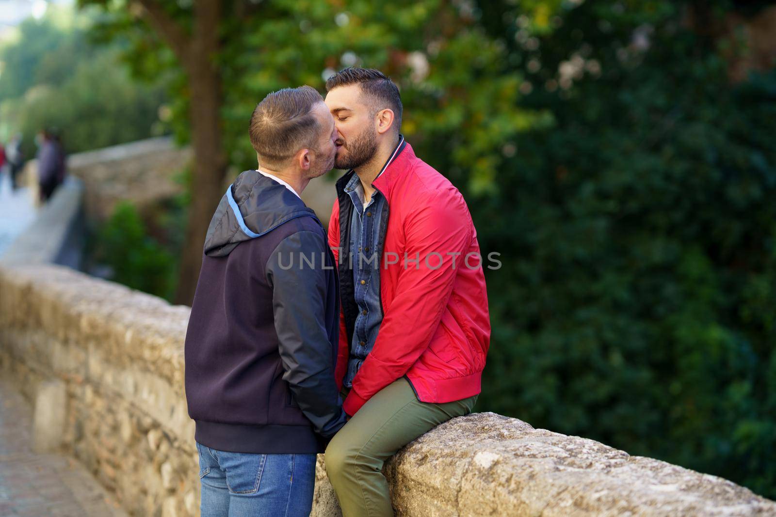 Gay couple kissing a beautiful place near the river. Homosexual relationship concept.