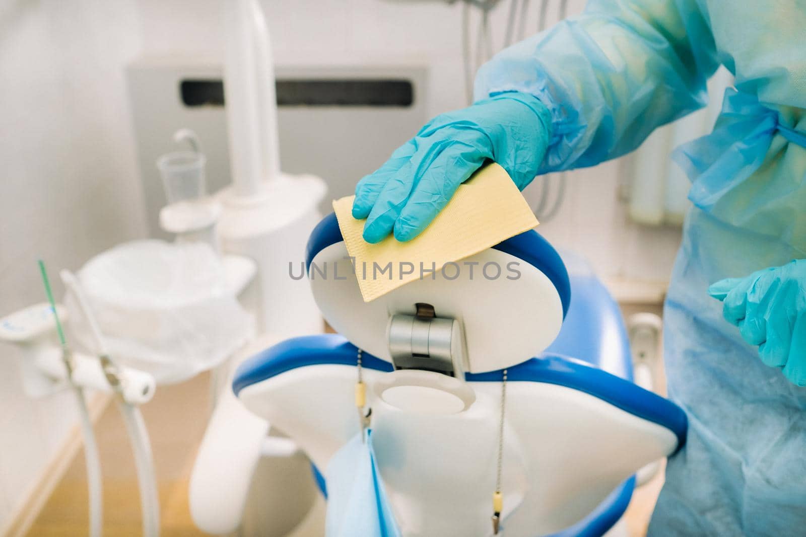 A nurse disinfects work surfaces in the dentist's office. by Lobachad