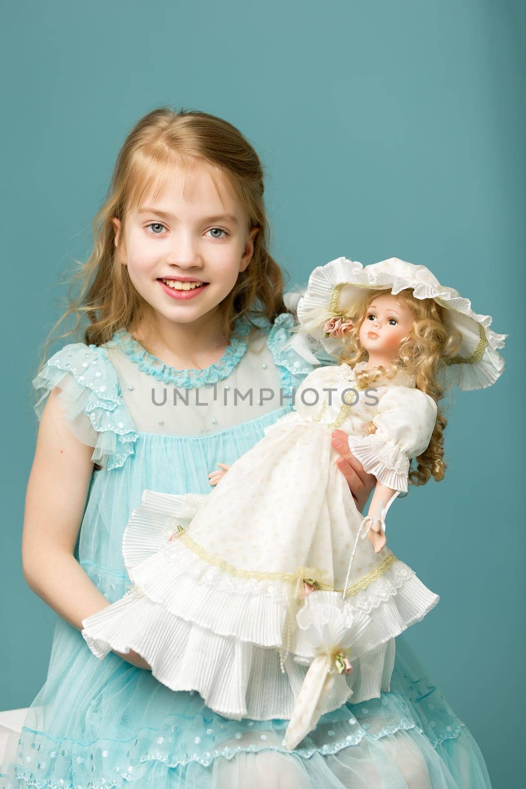 Adorable little girl playing with a doll. Concept of children's games, happy family.