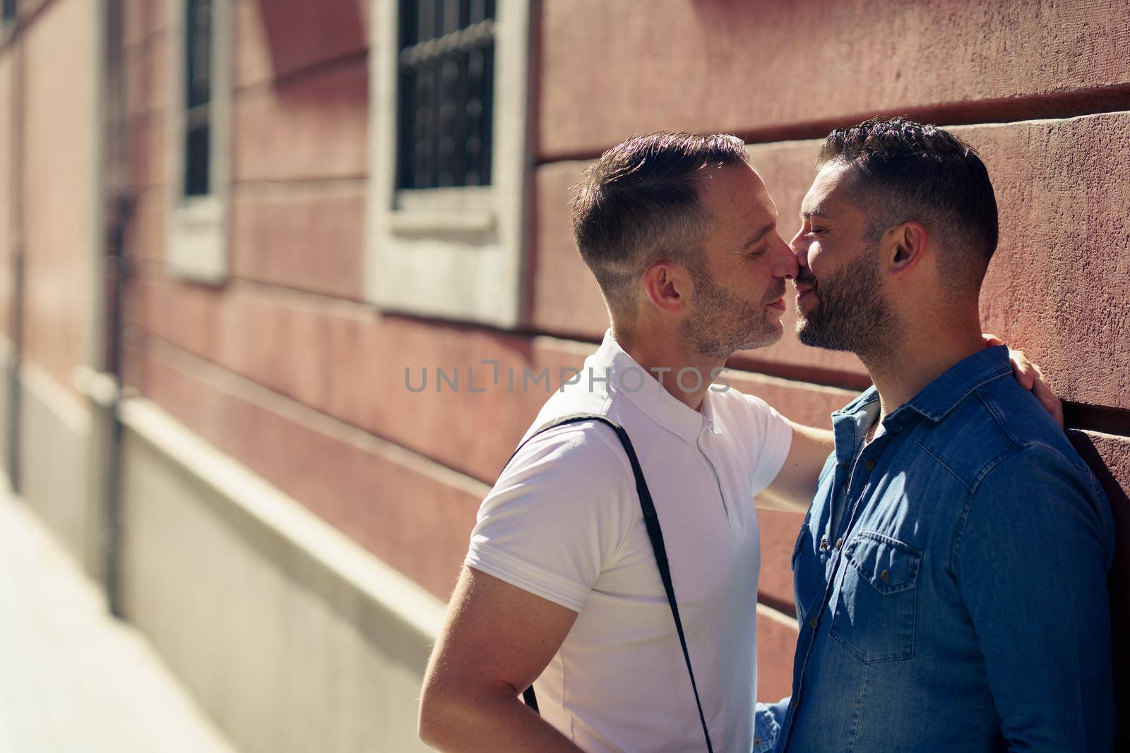 Gay couple kissing outdoors in urban background. by javiindy