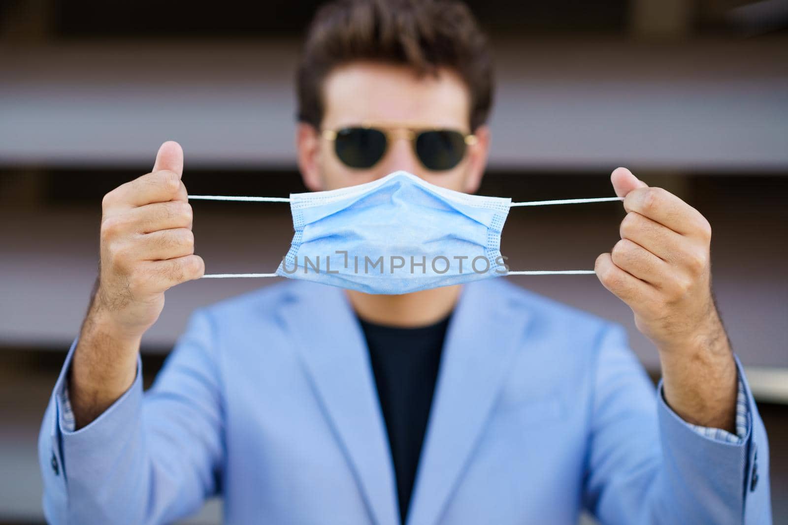 Caucasian businessman putting on a surgical mask to protect against the coronavirus.