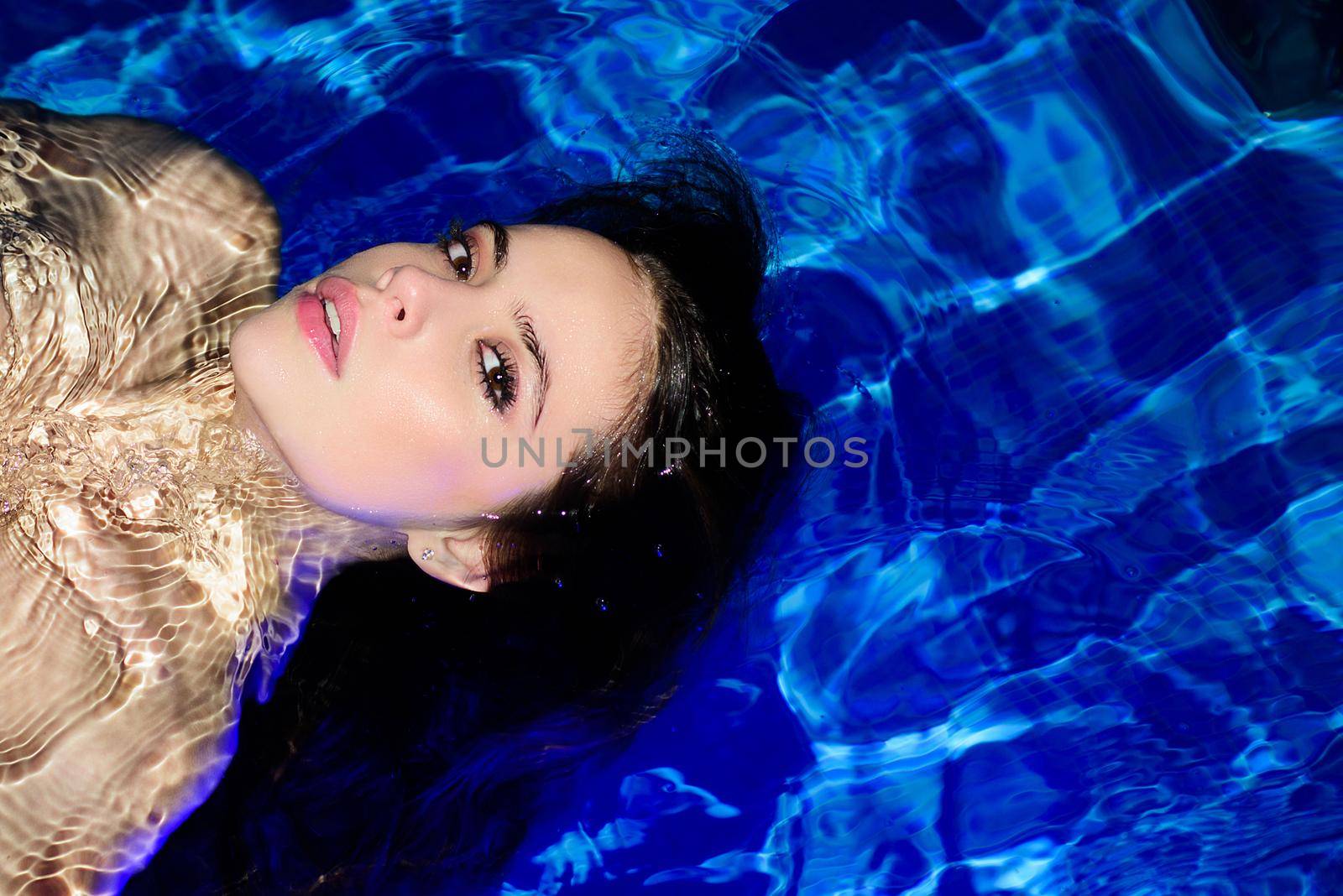 Young sexy attractive woman in pool, sensual look