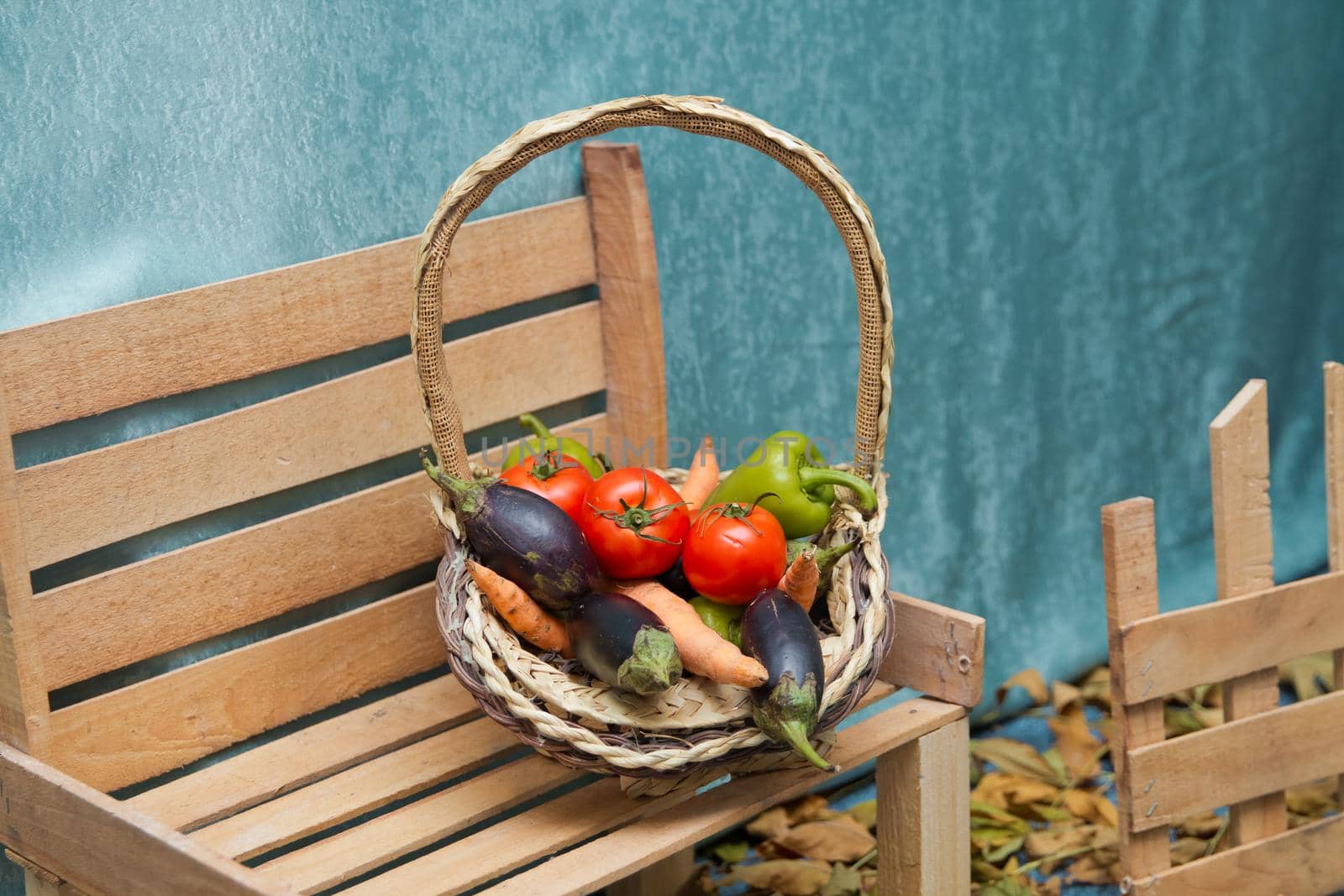 Autumn fruit in the basket. Tomato, pepper, markof, eggplant. Bench to the right. Autumn scene. by Adil_Celebiyev_Stok_Photo