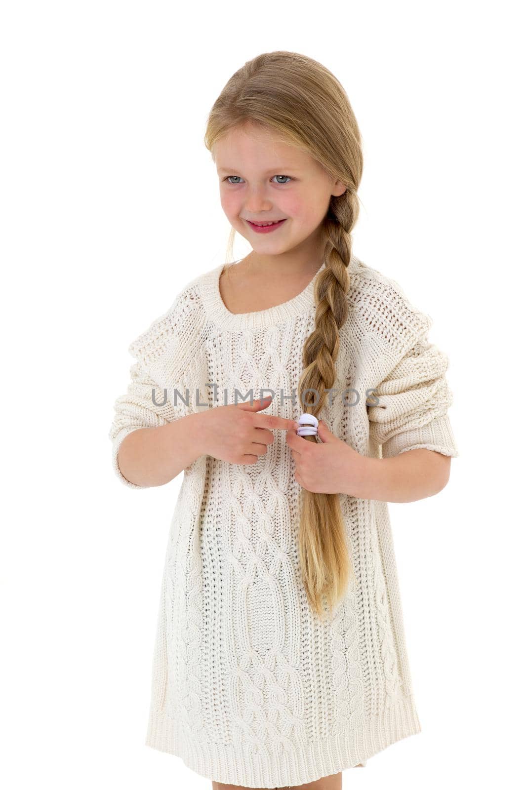 Beautiful happy little girl. Pretty blonde smiling girl with long braid wearing warm knitted dress having fun on isolated on white background.