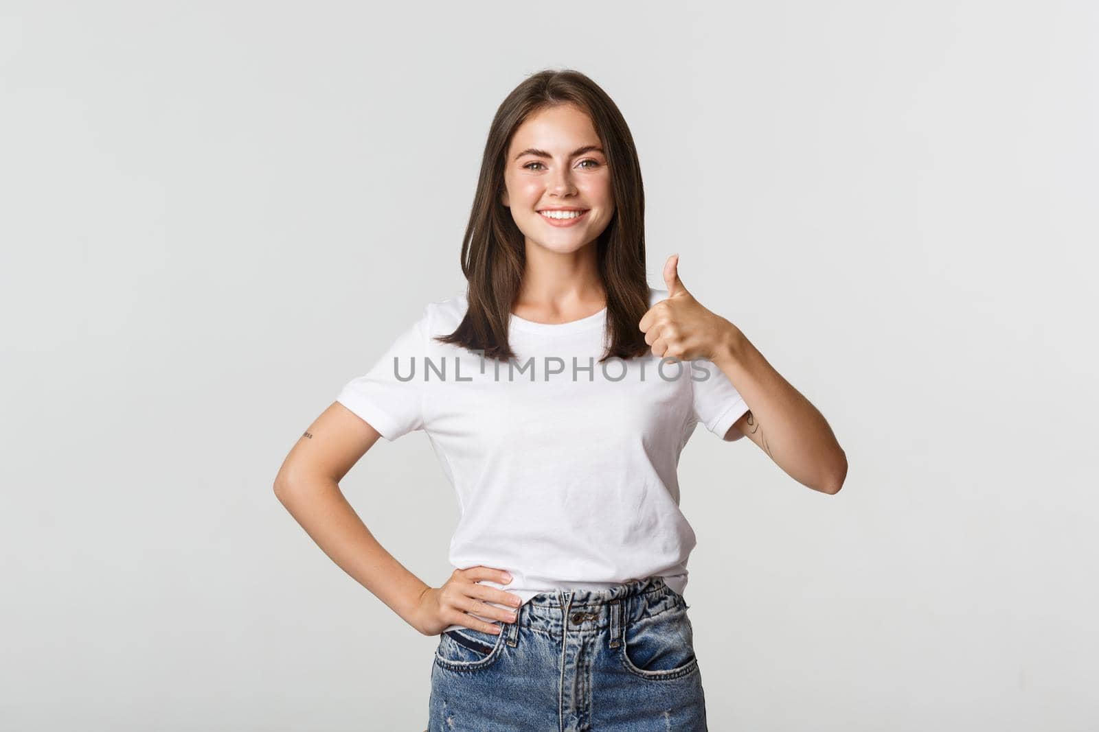 Happy satisfied young woman smiling, showing thumbs-up in approval, like something by Benzoix