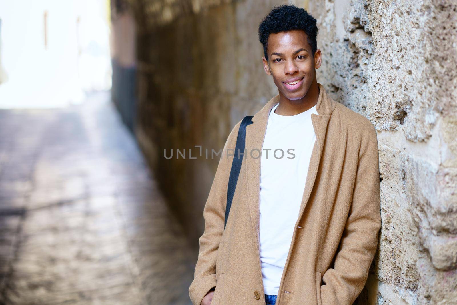 Young Cuban man standing in the street. Student in urban background.