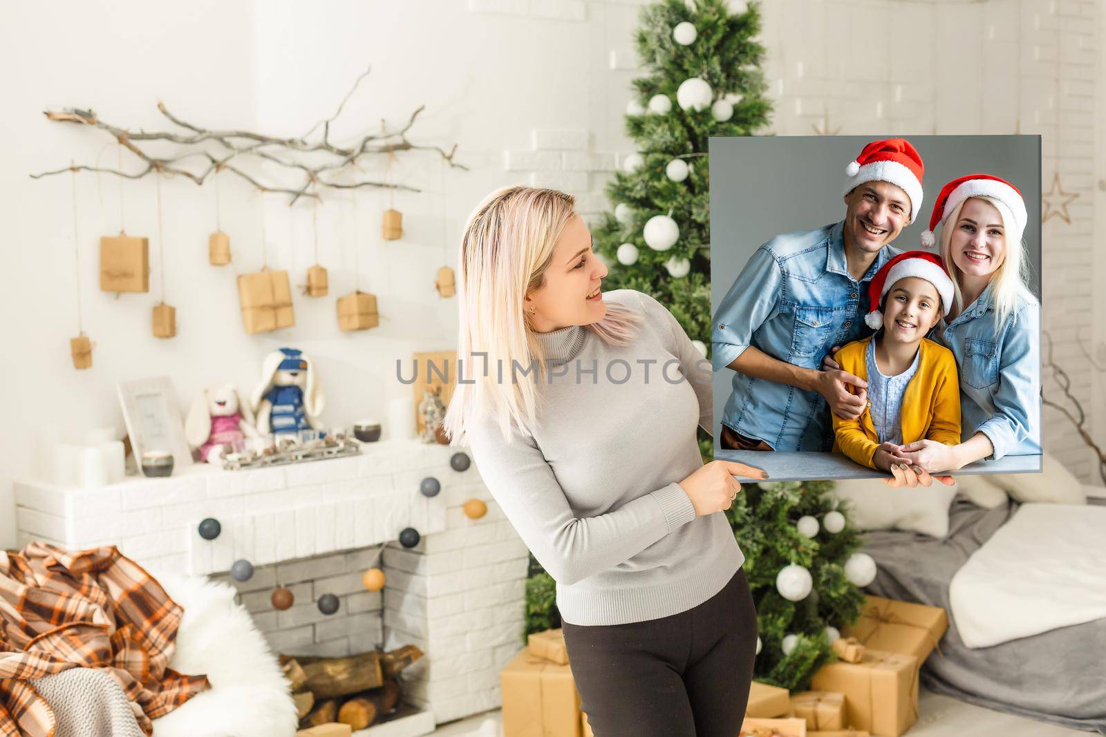 woman holding a photo canvas on the background of a Christmas interior.