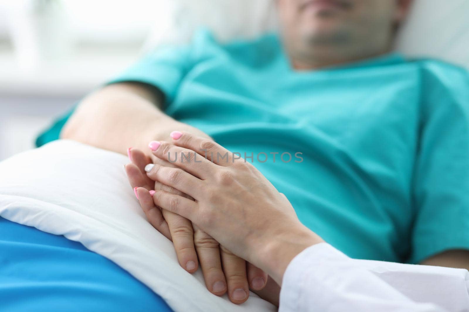 Doctors hands hold hands patient lying in ward. Treatment and prevention many diseases. Manifestations human attention to patients in serious condition. Highly qualified professional medical staff