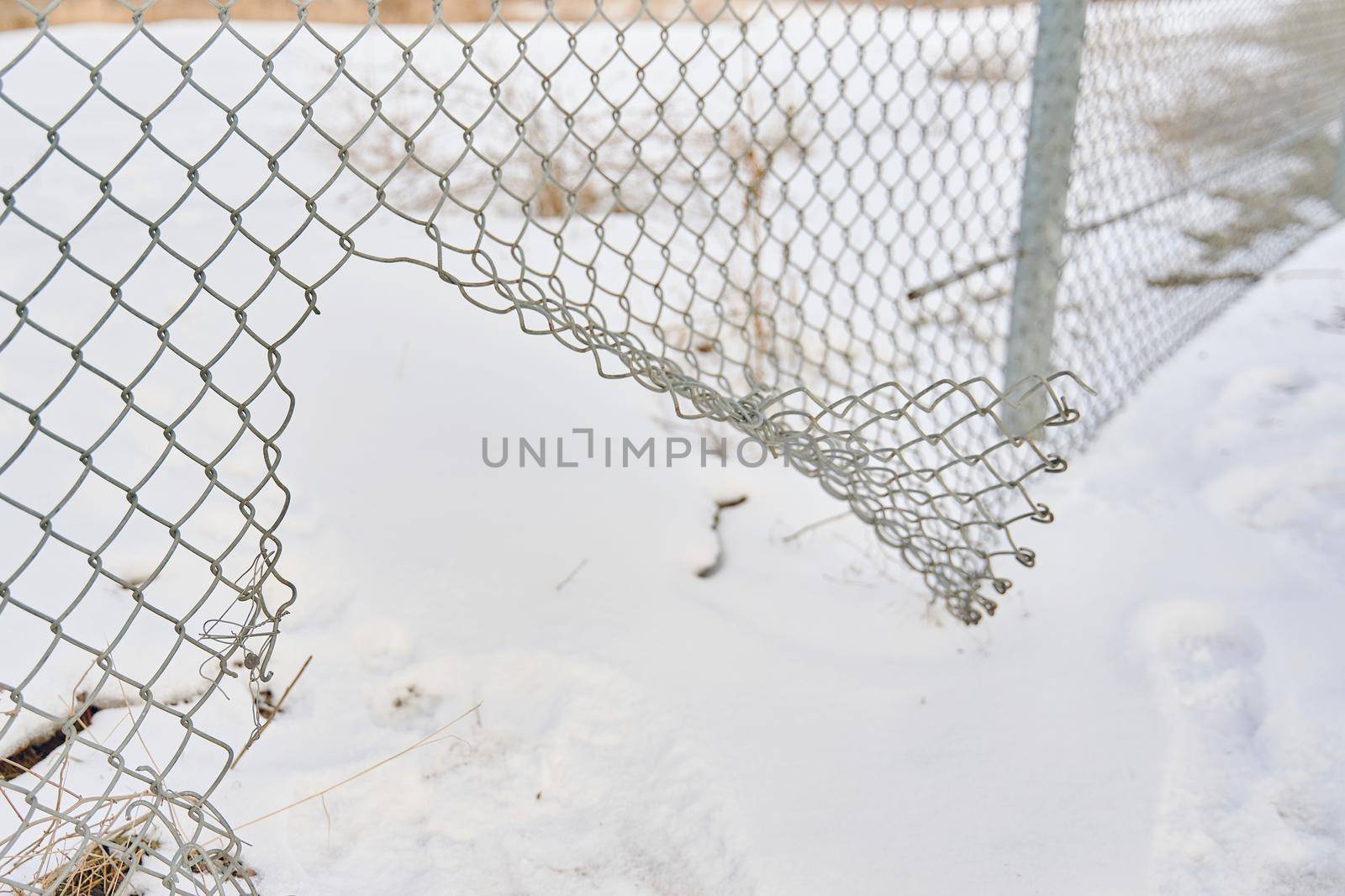 Hole in wire border fence. Maximum security detention facility. Illegal trespassing. Escape from prison or closed institution for mentally ill. Winter snowy weather. Unauthorized entry is prohibited.