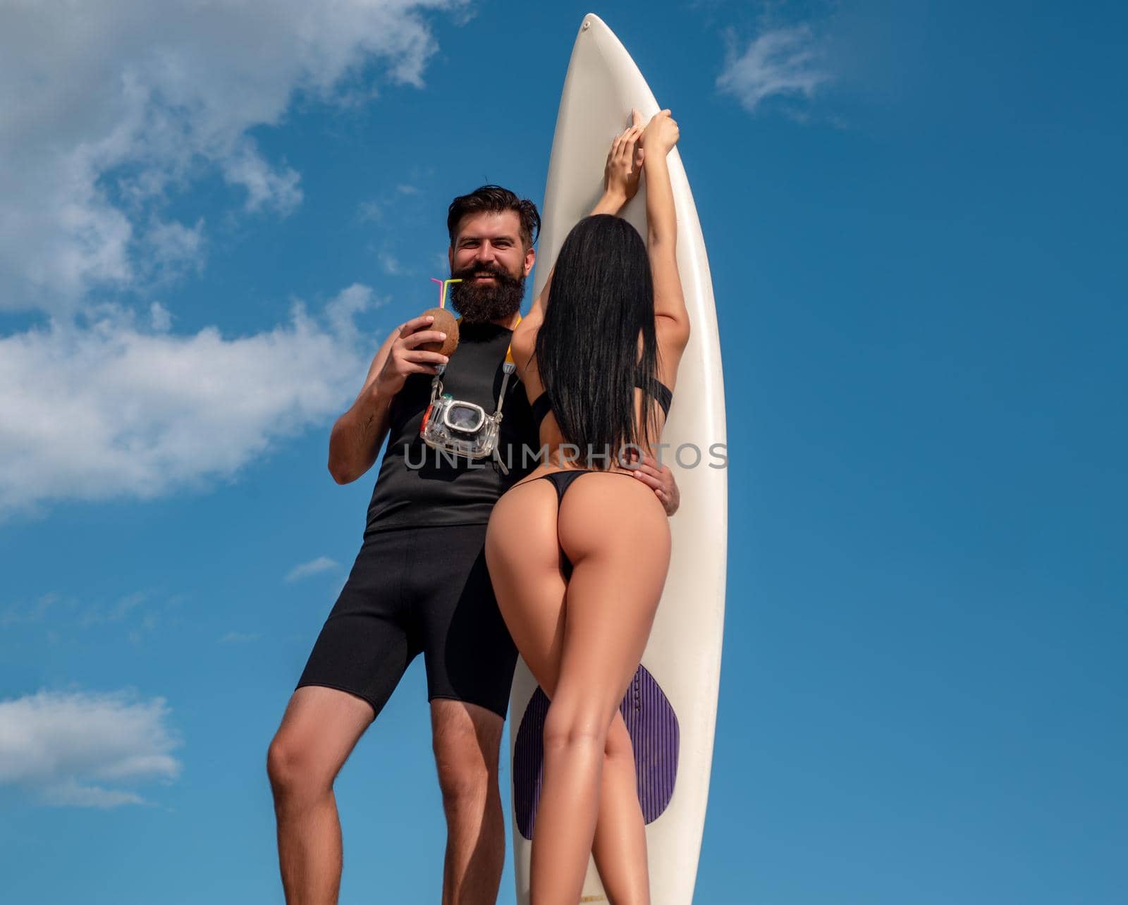 Sexy summer couples. Happy couple with Surfboard on the beach. by Tverdokhlib