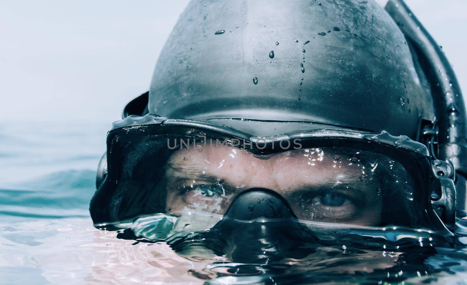 Young man diver looking out over the sea surface.