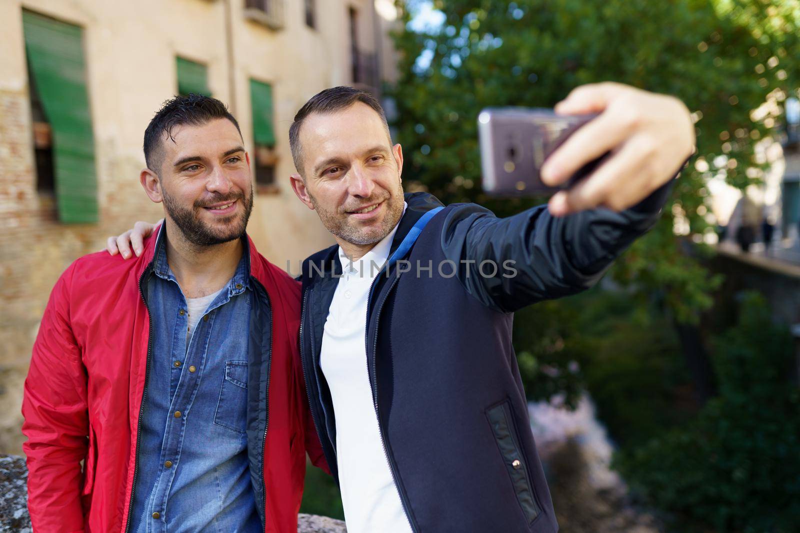 Gay couple making a selfie with their smartphone. Homosexual relationship concept.
