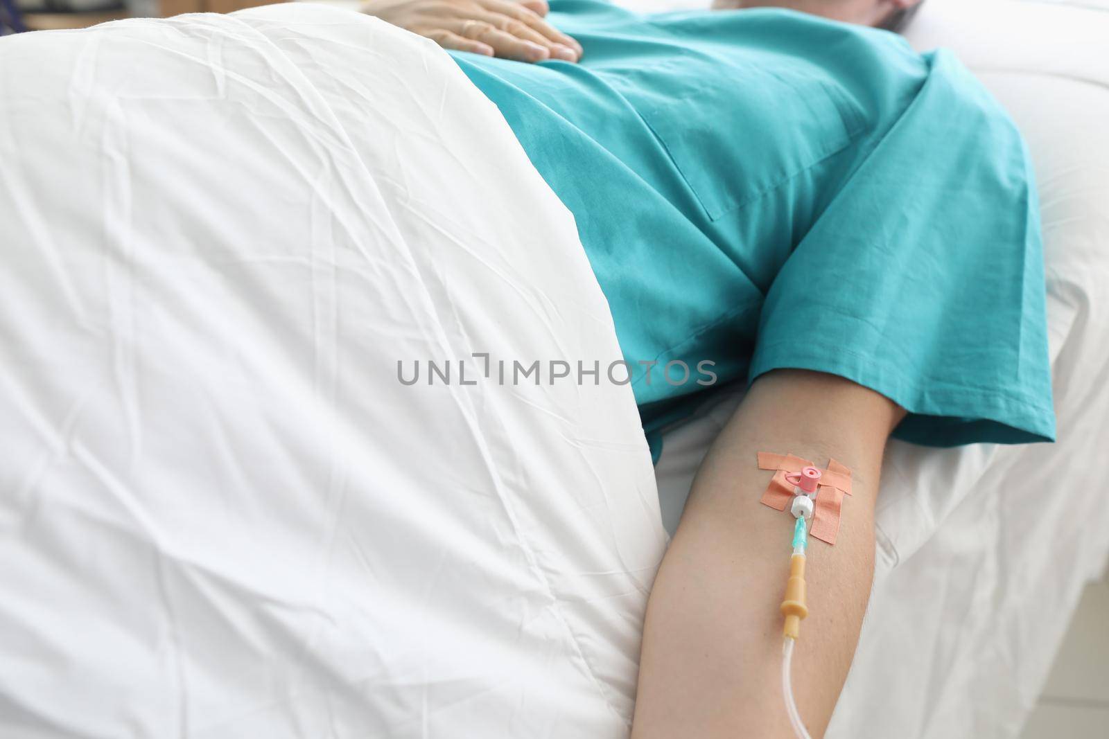 Man lies in hospital with syringe in vein his arm by kuprevich