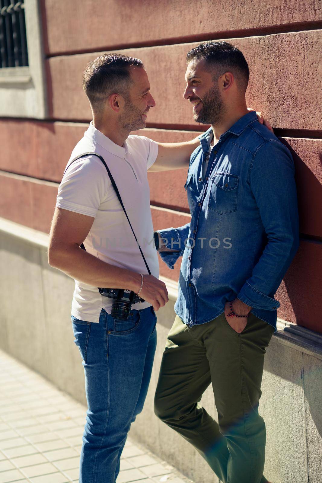 Gay couple tourists in a romantic moment on the street. Homosexual relationship concept.