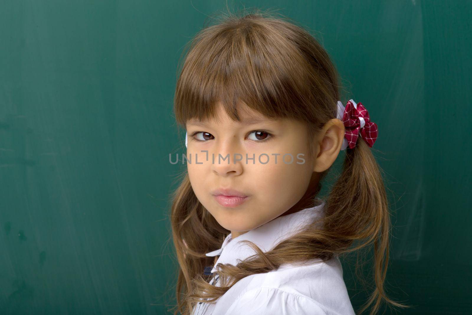 Happy girl posing at blackboard by kolesnikov_studio