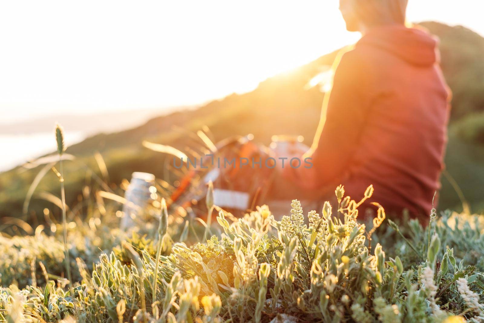 Traveler young woman resting in mountains in spring. Focus on foreground.