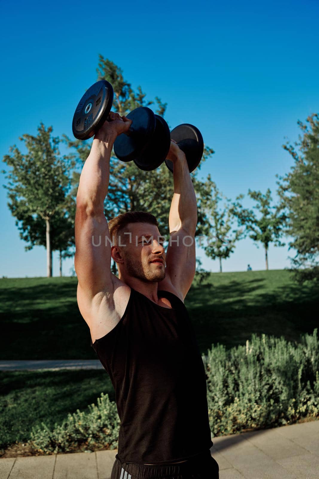 sporty man exercise fitness workout outdoors with dumbbells. High quality photo