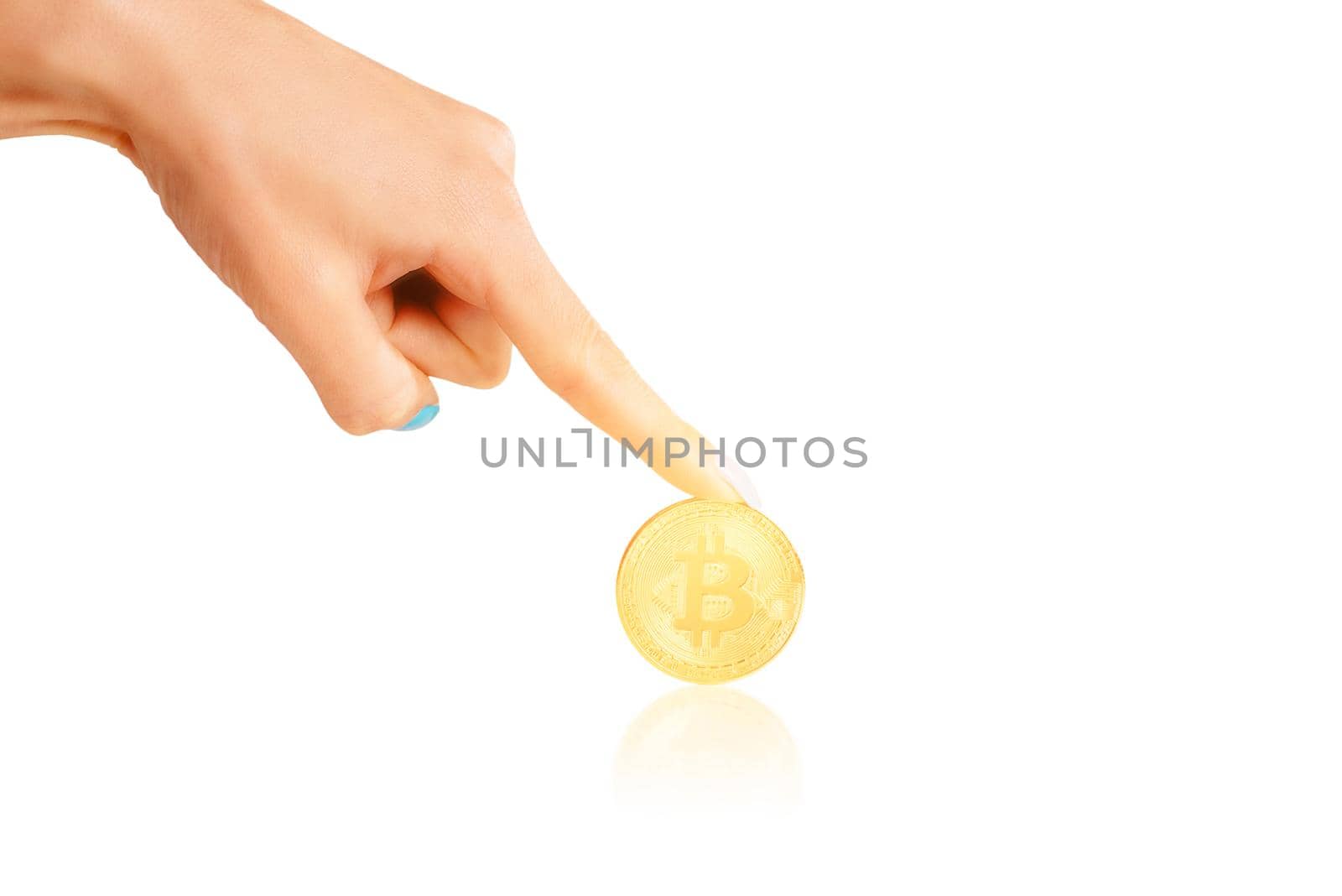 Female hand pointing to glowing gold bitcoin on a white background.