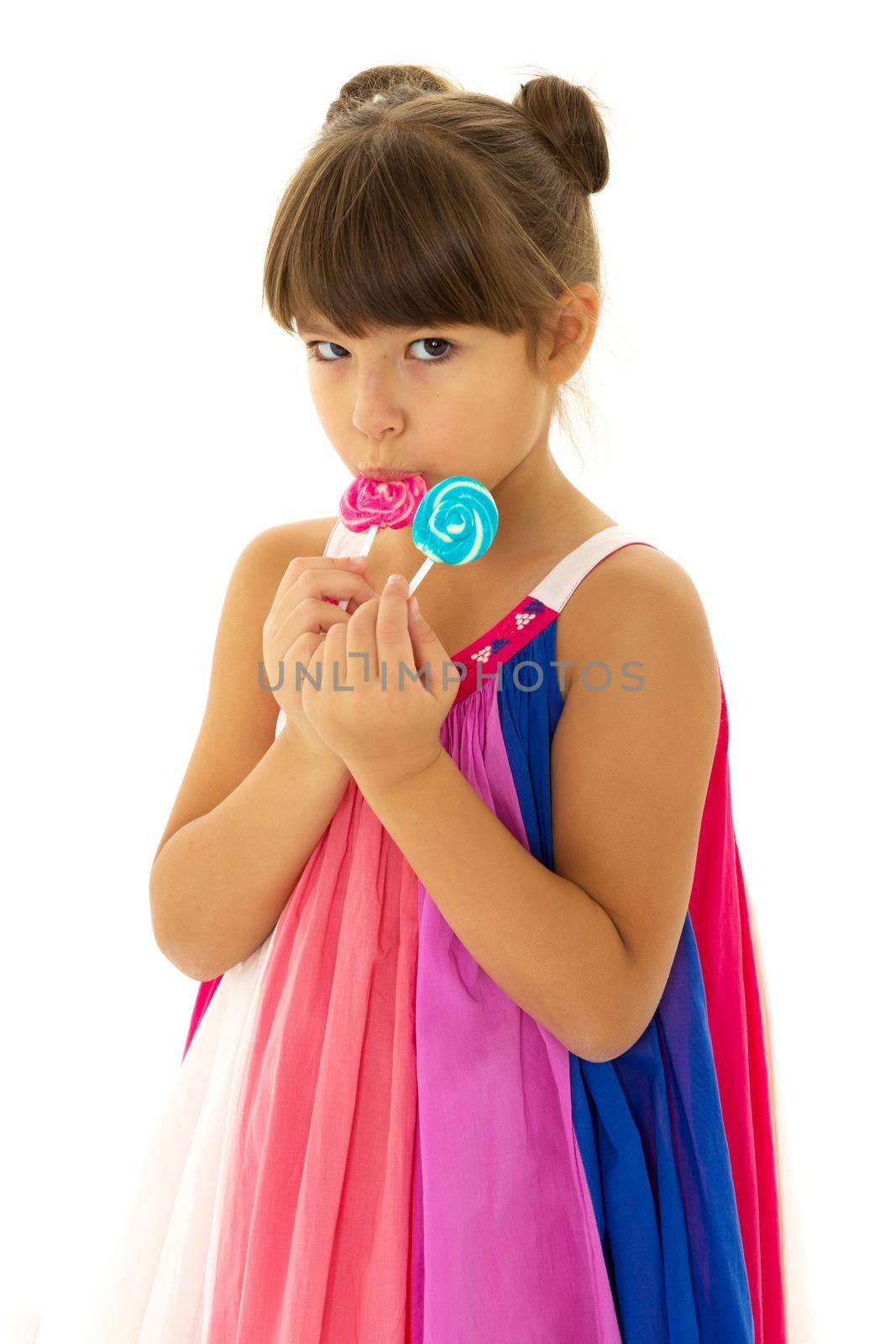 Pretty girl posing with lollipops. Lovely girl in bright summer dress posing in studio on isolated white background. Portrait of cute preteen child having fun with lollipops