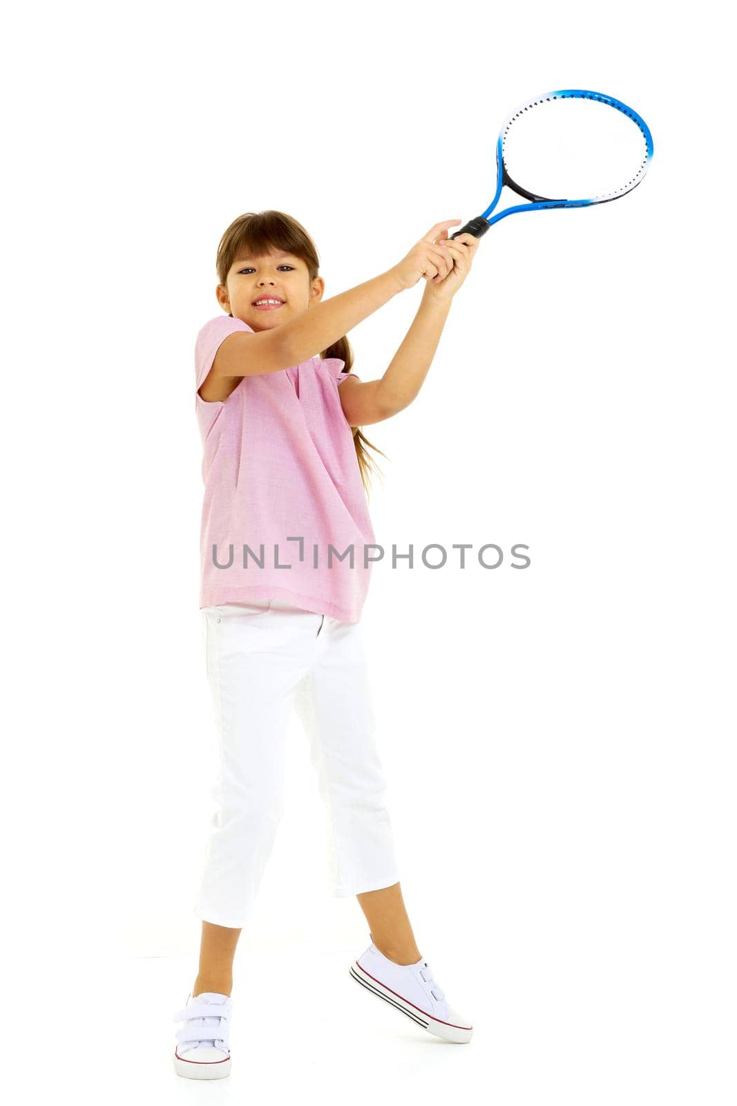 Happy playful girl smiling on the tennis court with a racket. Little girl with a tennis racket in a sports club. Active exercises for children. Training for a small child. The child learns to play. Isolated on white background.