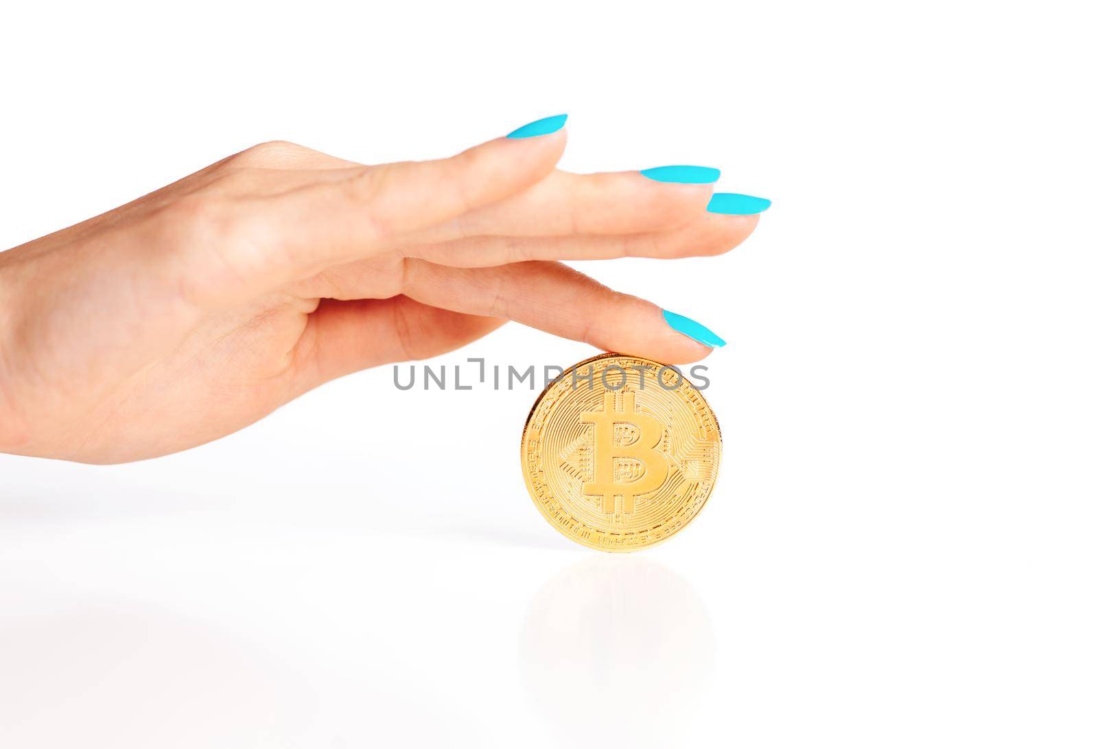 Female hand with gold coin bitcoin on a white background, virtual money.