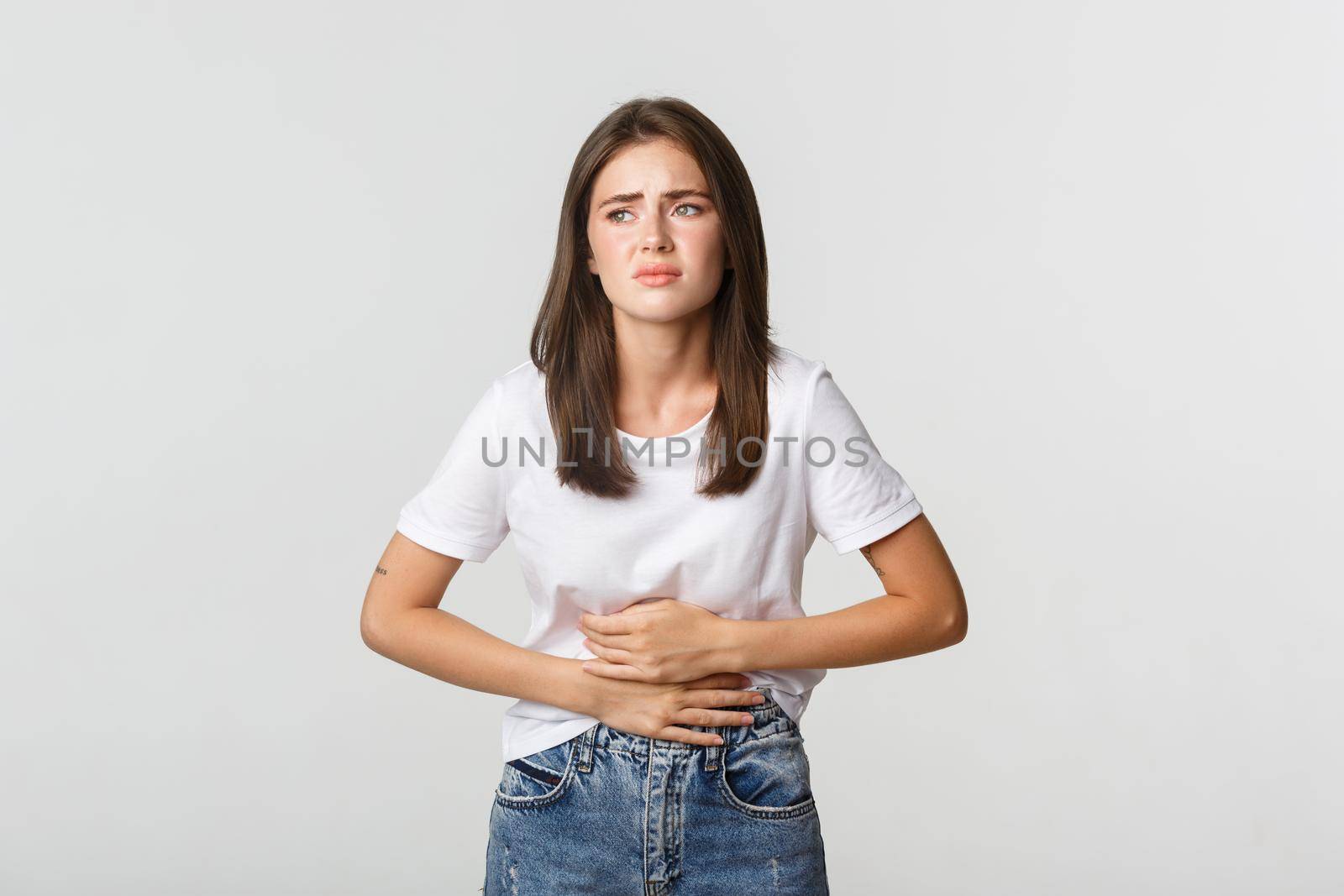 Woman having stomach ache, bending and holding hands on belly, discomfort from menstrual cramps by Benzoix