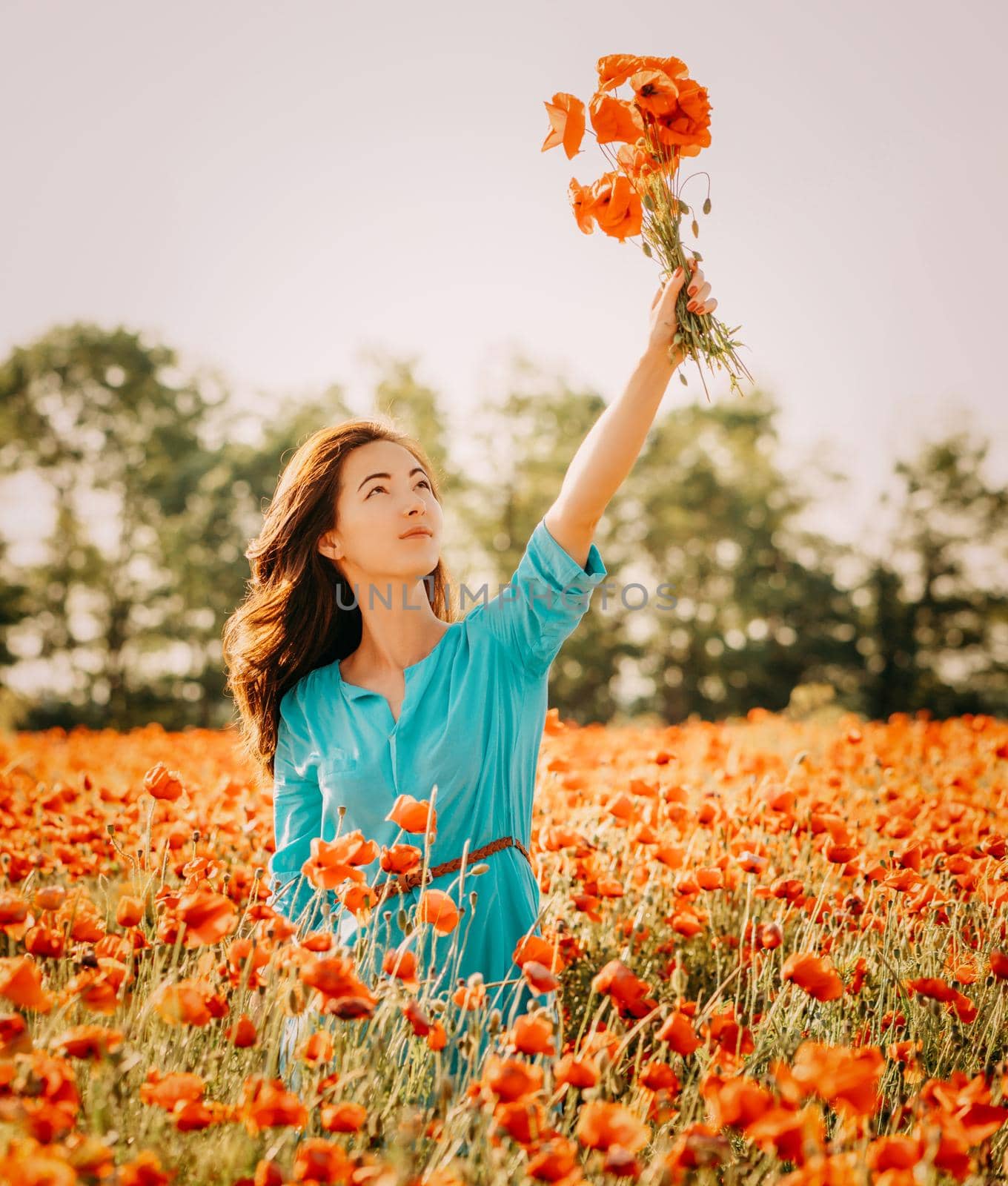 Beautiful girl with bouquet of poppies in summer field. by alexAleksei