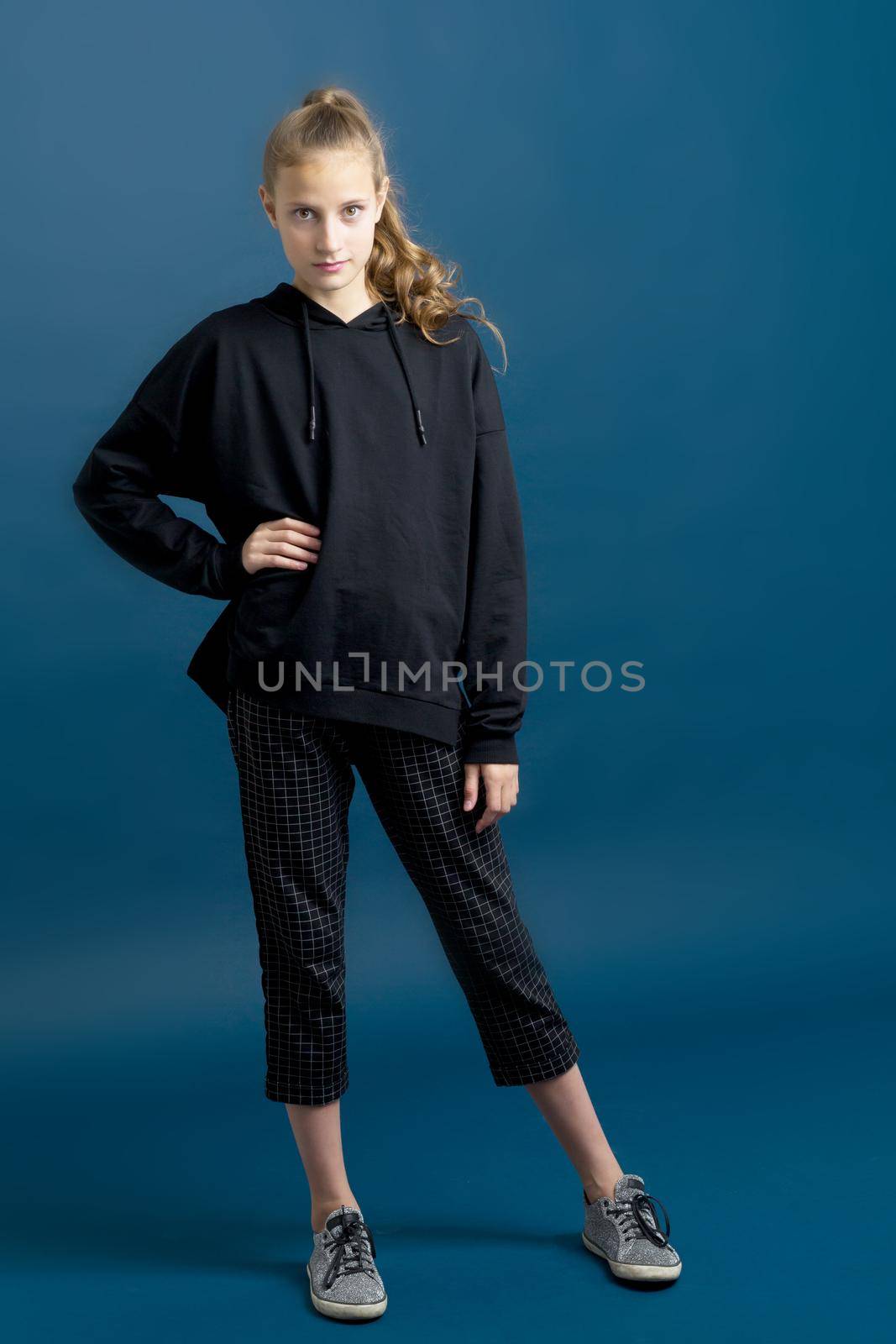 Pretty teenage girl in black hoodie. by kolesnikov_studio