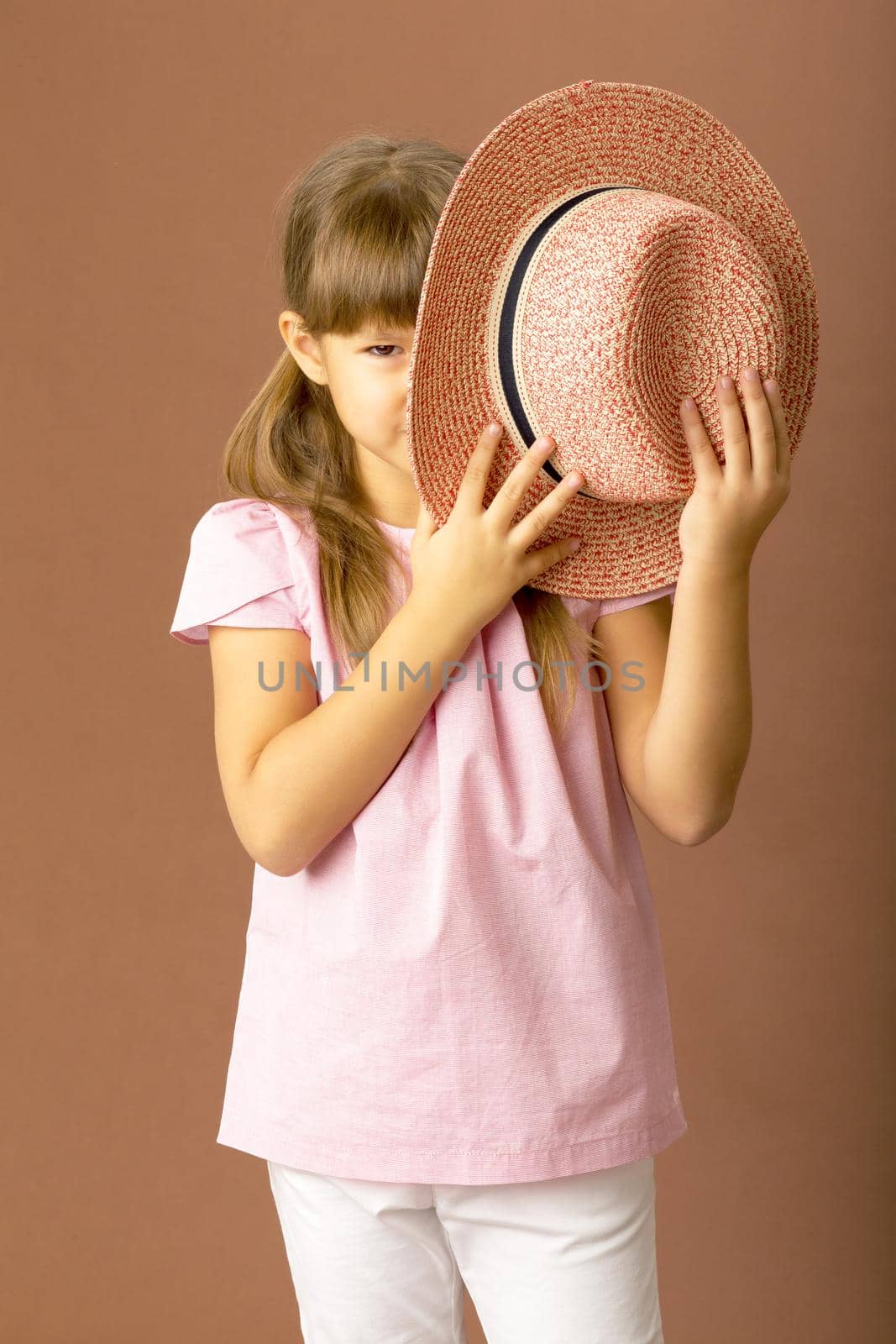 Girl covers her face with a straw hat by kolesnikov_studio