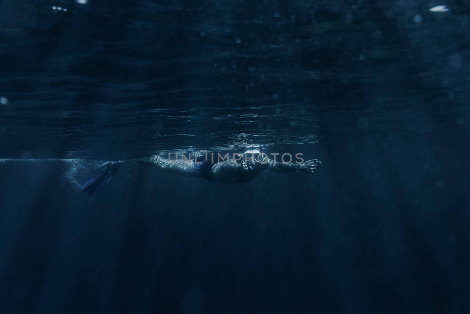 Man swimming underwater surface. by alexAleksei