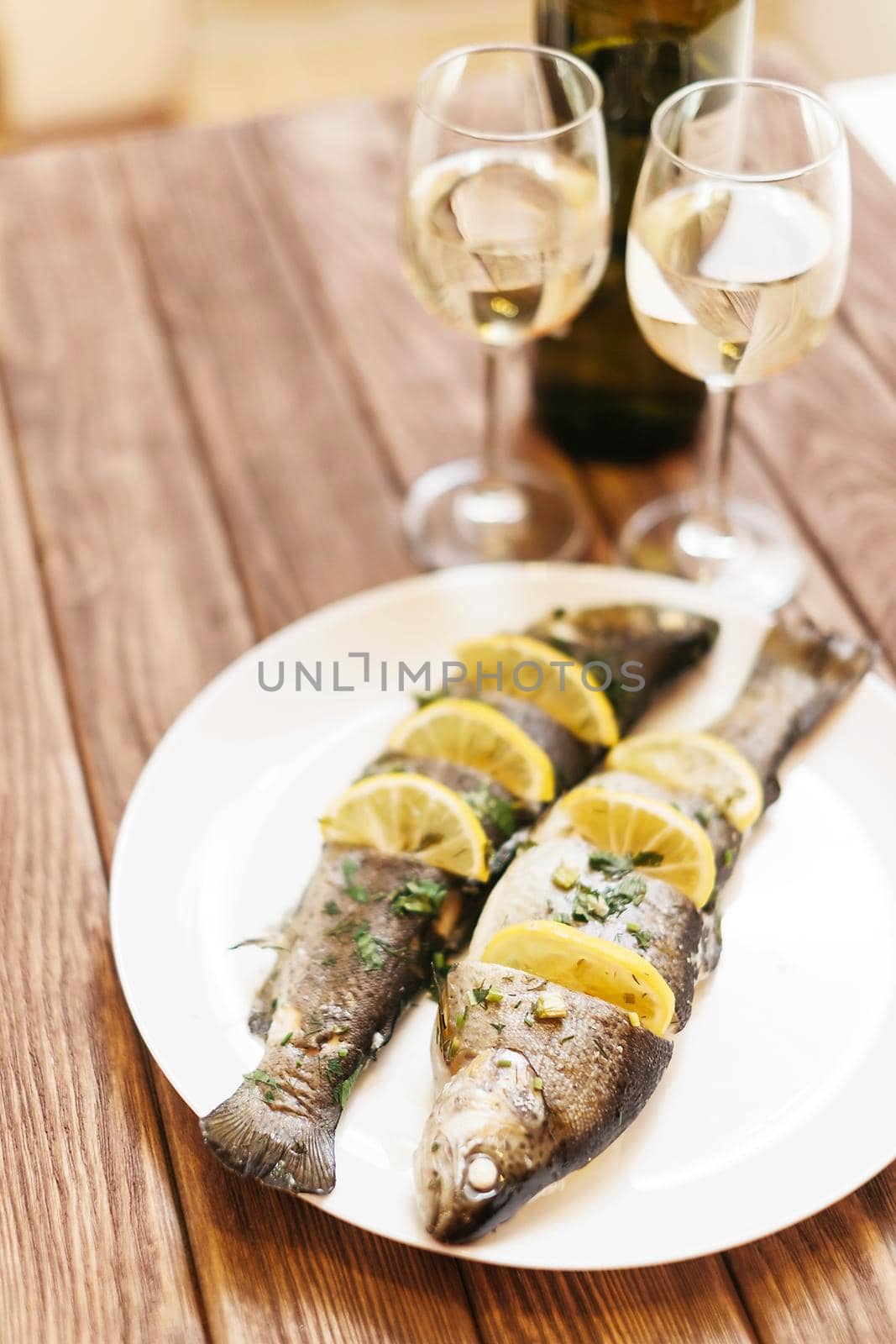 Fish dish and glasses of wine for couple. by alexAleksei