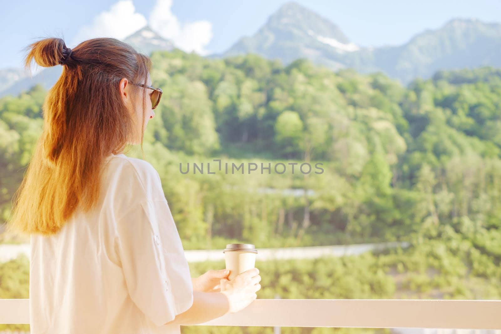 Woman relaxing on balcony with cup of coffee. by alexAleksei