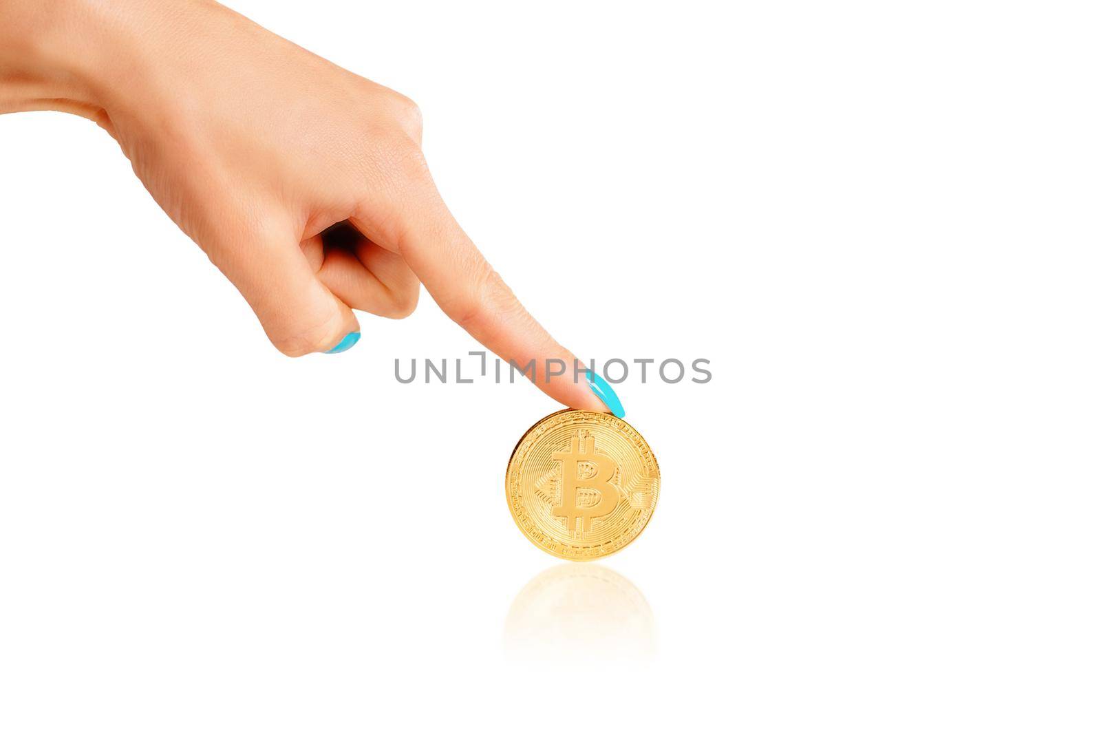 Female hand pointing to gold coin bitcoin on a white background, copy-space.