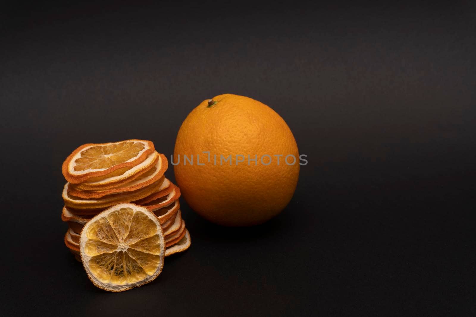 Oranges naturmort, still life, sliced dried oranges and whole orange at black background, beautiful concept for painting.