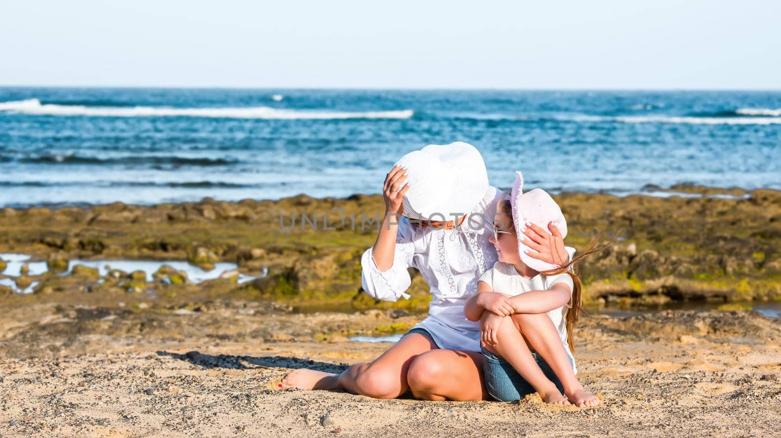happy mother with daughter playing on the beach