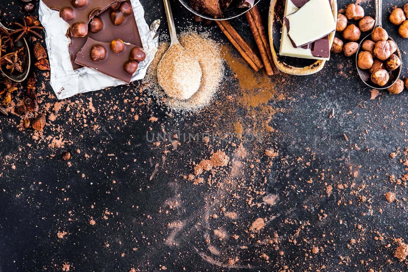 chocolate, cocoa and various spices on black table