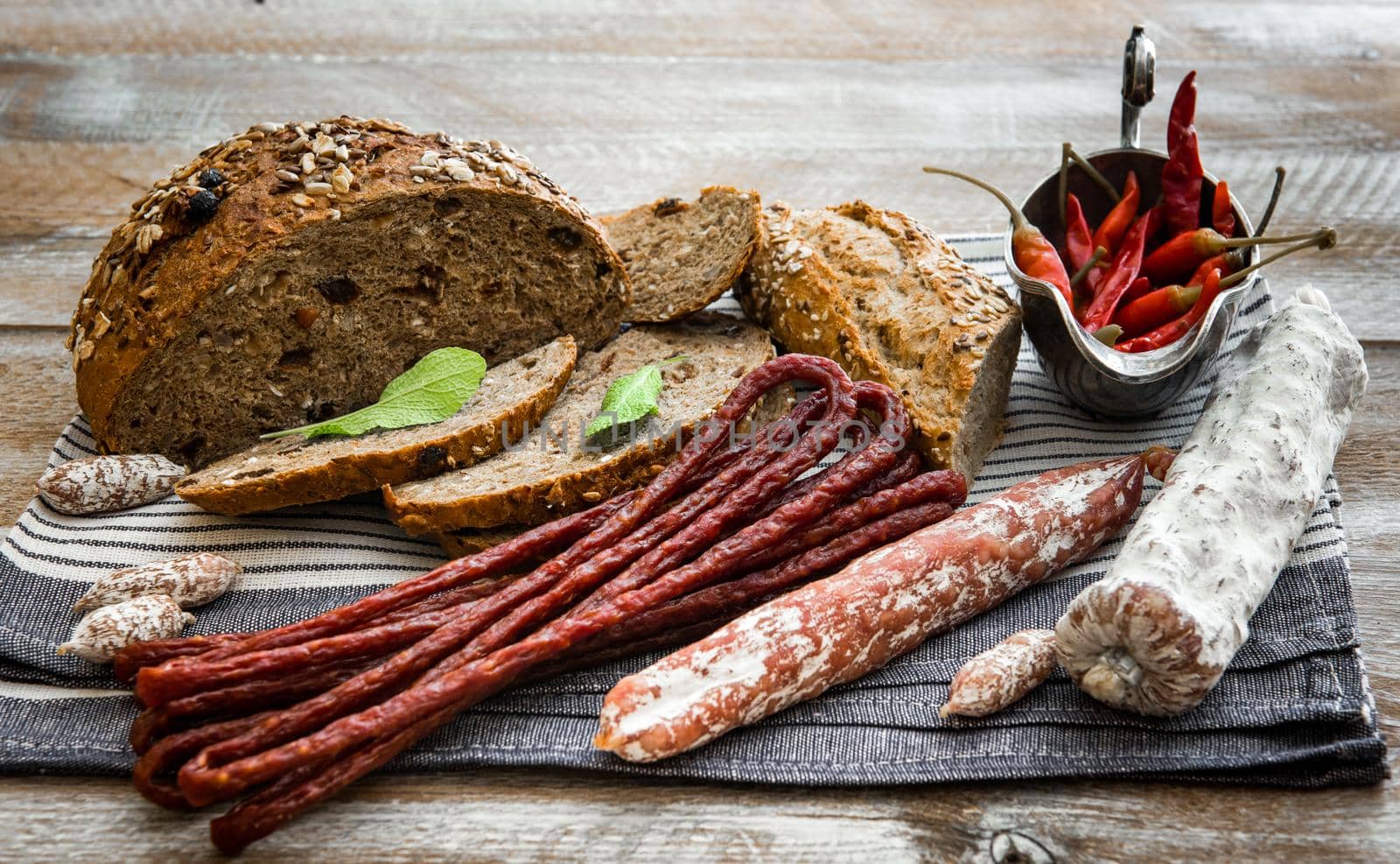 bread with dried sausages on a wooden table