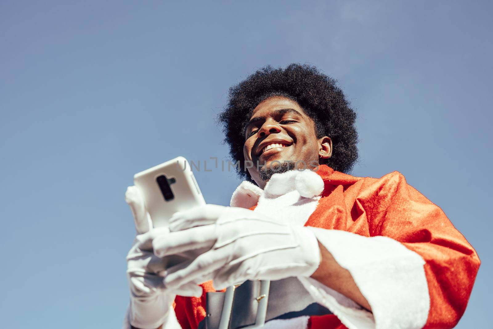 afro santa claus using mobile phone. View from below